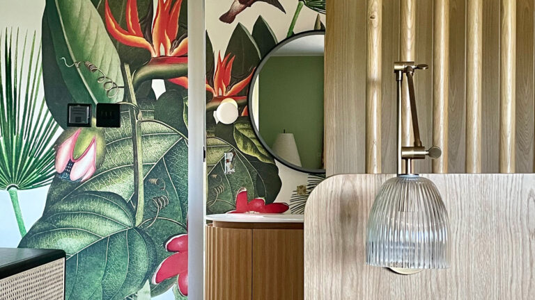 Detail of family home renovation project with bed reading light, patterned wallpaper and bathroom mirror.